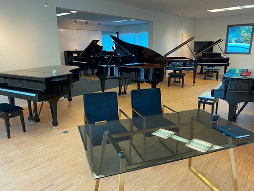 Beratungstisch in der Ausstellung von Piano Hoffmann, umgeben von Flügeln