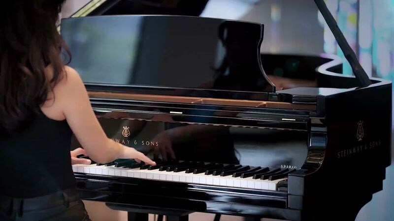 Pianistin an einem schwarzen Steinway-Flügel
